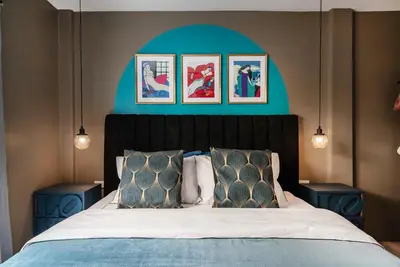 a bedroom with a large bed with two blue tables at The Mellow at Silom in Bangkok