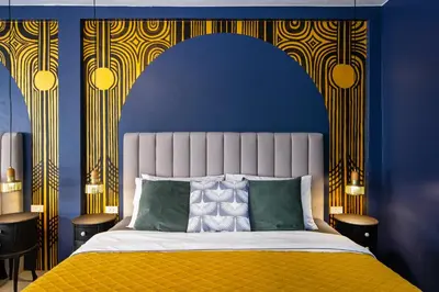 a bedroom with a blue and yellow wall with a bed at The Mellow at Silom in Bangkok