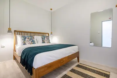 a bedroom with a bed with a green blanket at The Mellow at Thong Lo in Bangkok