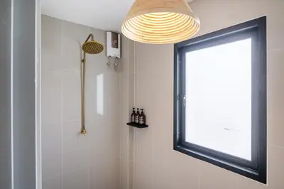 a bathroom with a shower and a window at The Mellow at Thong Lo in Bangkok