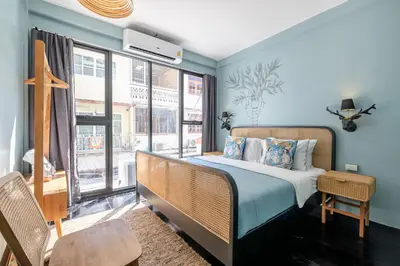 a bedroom with a bed and a large window at The Mellow at Thong Lo in Bangkok