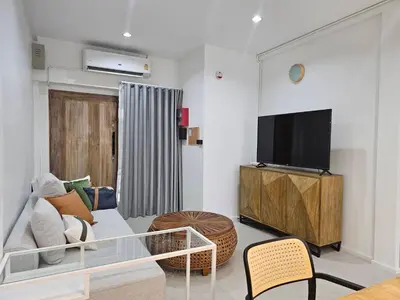 a living room with a couch and a flat screen tv at The Mellow at Thong Lo in Bangkok