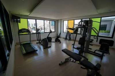 a gym with treadmills and exercise equipment in a building at iSanook Bangkok in Bangkok