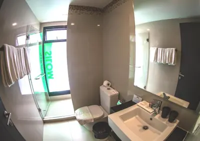 a bathroom with a toilet and a sink and a mirror at iSanook Bangkok in Bangkok