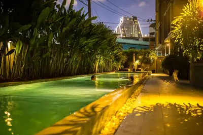 a swimming pool with people in it at night at iSanook Bangkok in Bangkok