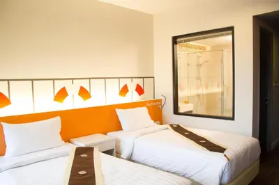 a hotel room with two beds and a mirror at iSanook Bangkok in Bangkok
