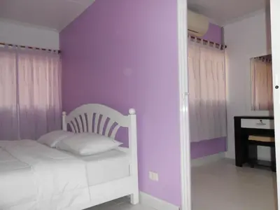 a bedroom with a white bed and purple walls at MT-Room in Bangkok