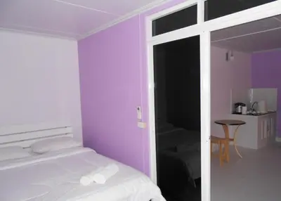 a bedroom with purple walls and a bed and a table at MT-Room in Bangkok