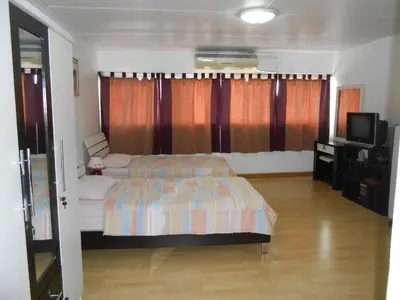 a bedroom with a bed and a television in it at MT-Room in Bangkok