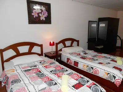 two beds sitting next to each other in a room at MT-Room in Bangkok