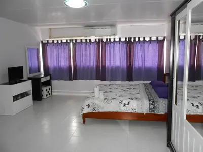 a bedroom with a bed and purple curtains at MT-Room in Bangkok