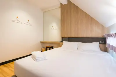 a bedroom with two beds with white sheets at T Hostel @ Victory Monument in Bangkok