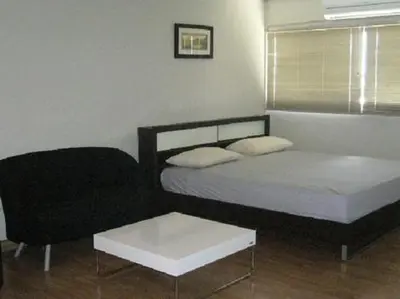 a small bedroom with a bed and a chair at DMK Don Mueang Airport Guest House in Bangkok