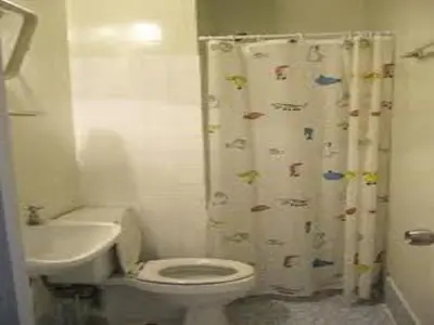 a bathroom with a toilet and a shower curtain at DMK Don Mueang Airport Guest House in Bangkok