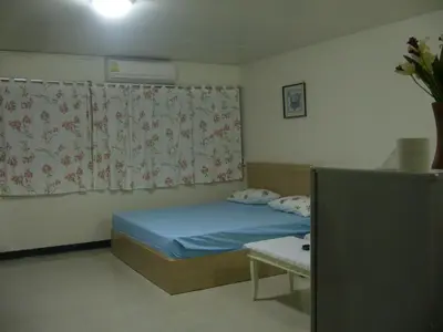 a small bedroom with a bed and a window at DMK Don Mueang Airport Guest House in Bangkok