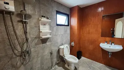 a bathroom with a shower and a toilet and a sink at Krung Boutique Hotel in Bangkok