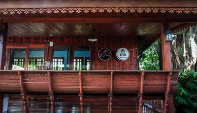 a wooden bar with clocks on the wall at โรงแรมบ้านเพิ่มสุข อิมแพ็ค เมืองทอง in Pak Kret