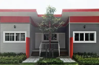 a house with a tree in front of it at โรงแรมบ้านเพิ่มสุข อิมแพ็ค เมืองทอง in Pak Kret