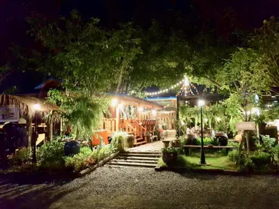a night view of a house with lights at โรงแรมบ้านเพิ่มสุข อิมแพ็ค เมืองทอง in Pak Kret