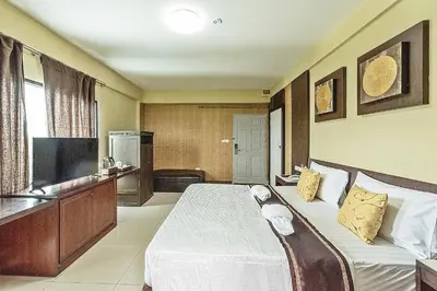 a hotel room with a bed and a flat screen tv at The Wing Design Hotel in Bangkok