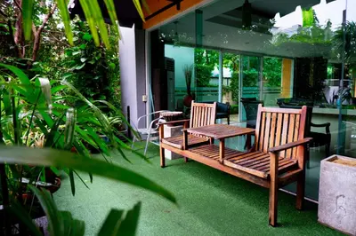 two wooden chairs and a table on a patio at The Wing Design Hotel in Bangkok