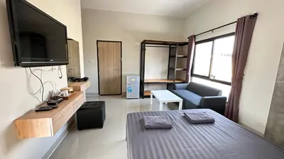 a living room with a couch and a flat screen tv at Buathong Pool Villa in Ban Khung Taphao