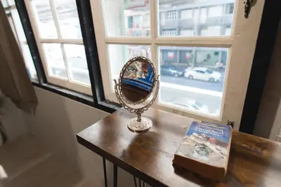 a mirror sitting on a table next to a window at Bangpho Story in Bangkok