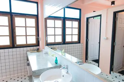 a bathroom with two sinks and two mirrors at Bangpho Story in Bangkok
