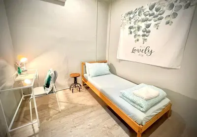 a small room with a bed and a painting on the wall at Bangpho Story in Bangkok