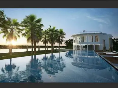 a large swimming pool in front of a house with palm trees at river front in Nonthaburi