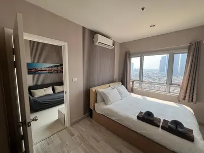 a small bedroom with a bed and a window at river front in Nonthaburi