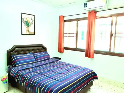 a bedroom with a bed and two windows at U&D guest house in Bangkok