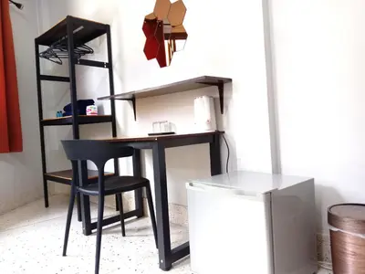 a black desk with a chair next to a shelf at U&D guest house in Bangkok