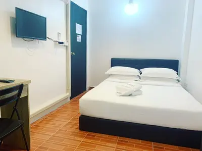 a bedroom with a bed with a tv on the wall at Gfeel Hostel in Bangkok