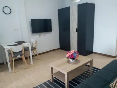a living room with a couch and a table and a tv at DD Garden Apartment 2 in Bangkok