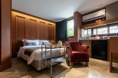 a hotel room with a bed and a red chair at B House 49 Bangkok in Bangkok