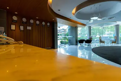 a lobby with a large wooden table and chairs at Royal Delight Hotel in Bangkok