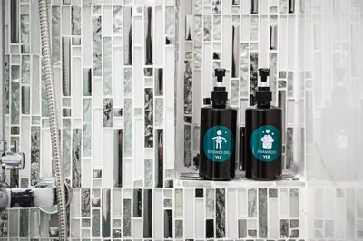 two bottles ofodorizers sitting on a shelf in a bathroom at VIX Bangkok at Victory Monument in Bangkok