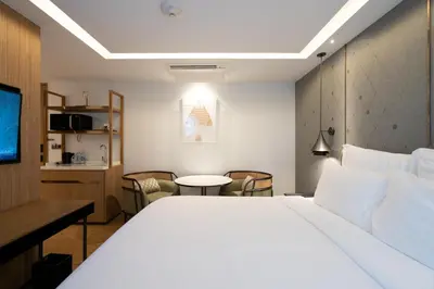 a hotel room with a bed and a table and chairs at Homm Sukhumvit34 Bangkok in Bangkok