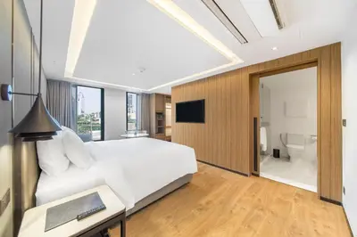 a bedroom with a large white bed and a bathroom at Homm Sukhumvit34 Bangkok in Bangkok