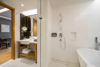 a bathroom with a shower and a tub and a sink at Homm Sukhumvit34 Bangkok in Bangkok