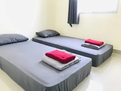 two beds in a room with red and white towels at Impact MT House in Ban Bang Phang