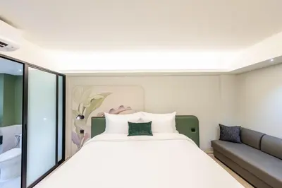 a bedroom with a large bed and a couch at Kaya Heritage Hotel in Bangkok