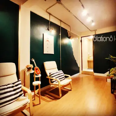 a living room with two chairs and a green wall at Station8 Hostel in Bangkok
