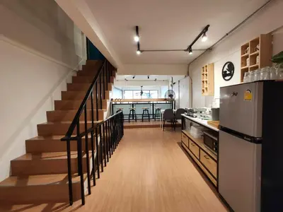 a kitchen with a staircase and a kitchen with a refrigerator at Station8 Hostel in Bangkok
