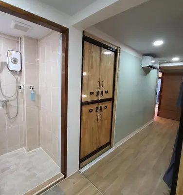 a bathroom with a shower with a wooden door at Station8 Hostel in Bangkok