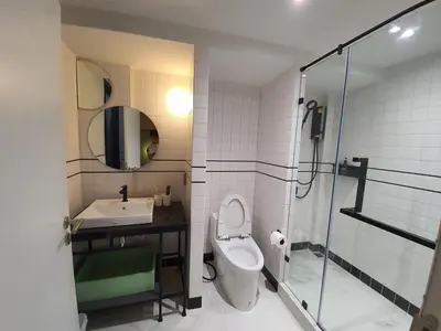 a bathroom with a toilet and a sink and a shower at Roompini in Bangkok