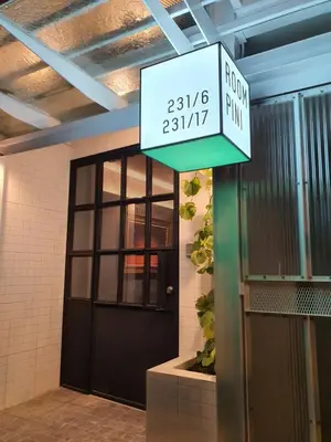 a sign that reads the front of a building with a door at Roompini in Bangkok