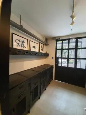 a room with a kitchen with a black door at Roompini in Bangkok