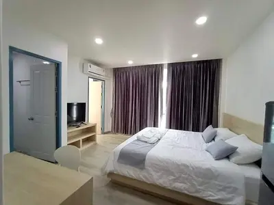 a bedroom with a large bed and a television at El Huq in Bangkok